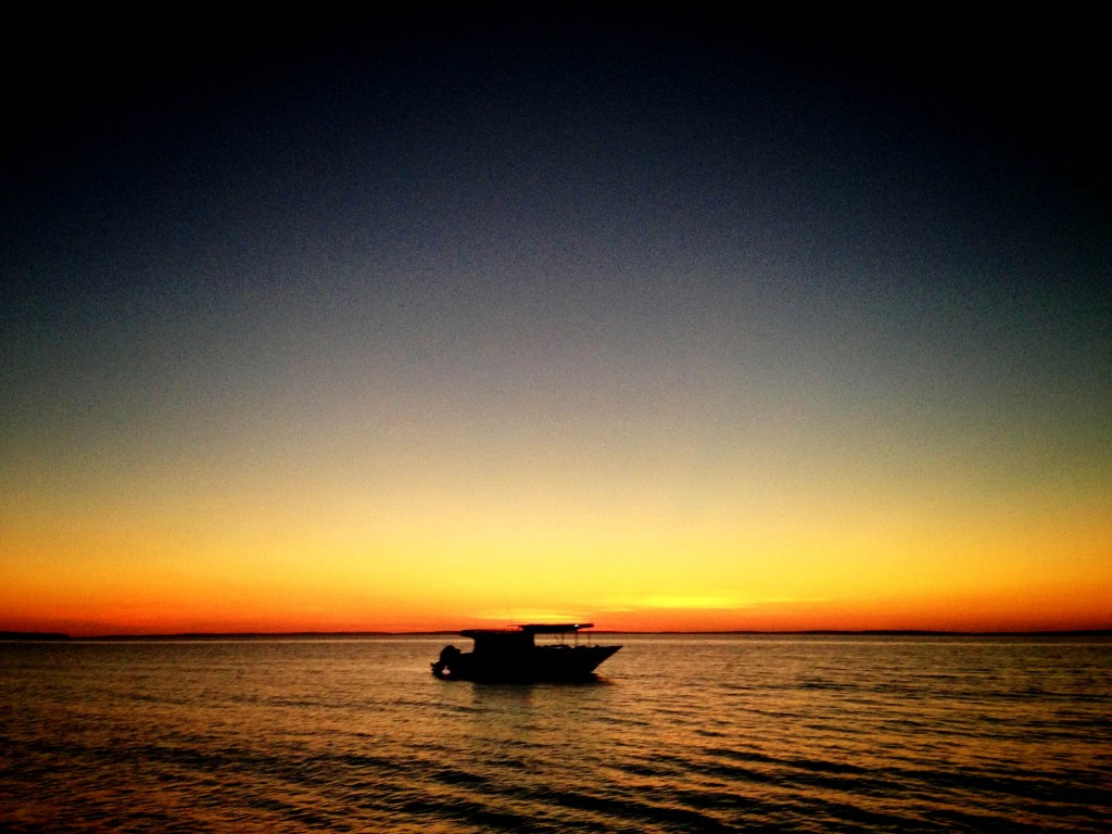 The sun setting behind the boat at Vanderlin Island